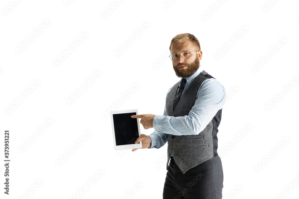 Cheerful handsome businessman isolated over white studio background, copyspace. Modern young director, manager in office suit, full length portrait. Using devices, gadgets. Business, finance, tech