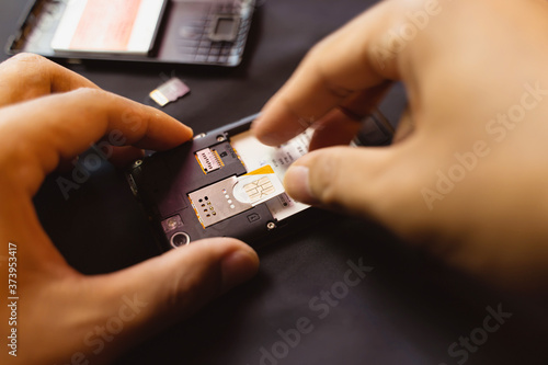 Employees are changing the phone SIM card, nano SIM card in the shop for customers to buy, Man's hand.