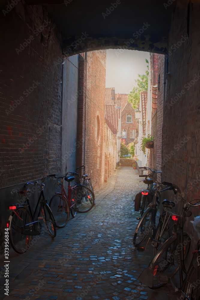 A dark old stone street in Bruges, Belnese, with bicycles standing there.