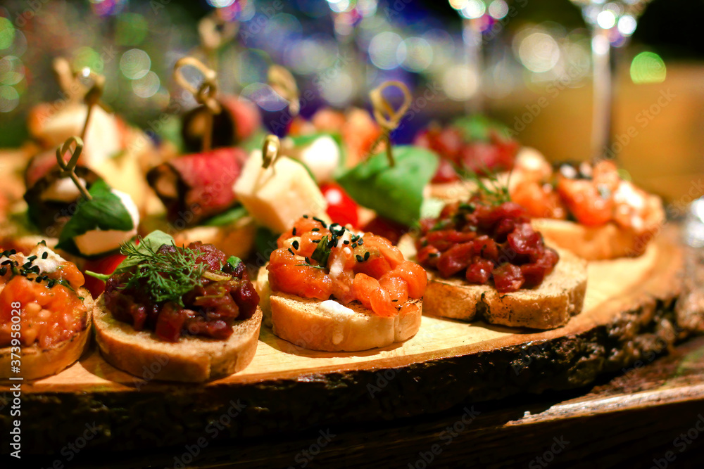 set of many different bruschettas at wooden table top. italian cuisine appetizer with tar tare set of many different bruschettas at wooden table top. italian cuisine appetizer with tar tare