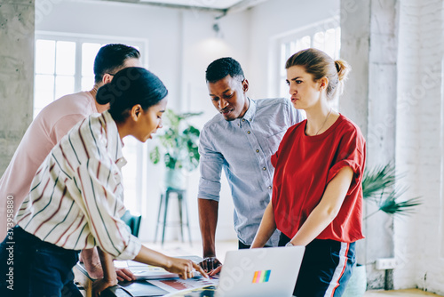 Group of diverse people discussing business plan of collaboration for startup project having brainstorming meeting in coworking space, team of intelligent hipster guys working together on task