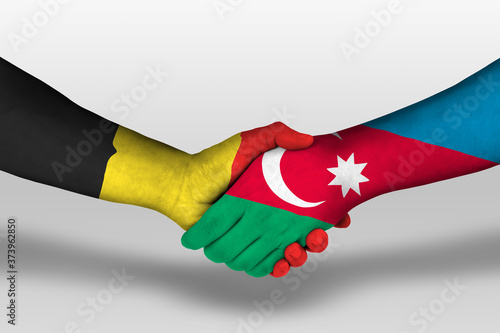 Handshake between azerbaijan and belgium flags painted on hands, illustration with clipping path.