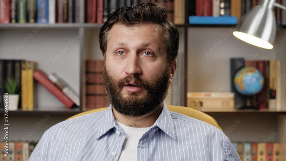 Tears, drama, melodrama, man crying concept. Man alone in room watches TV in evening, he is sad and cries, wipes his eyes with paper napkin. Close-up