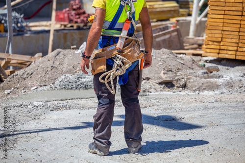 Worker with tools in toolbelt and construction tools photo