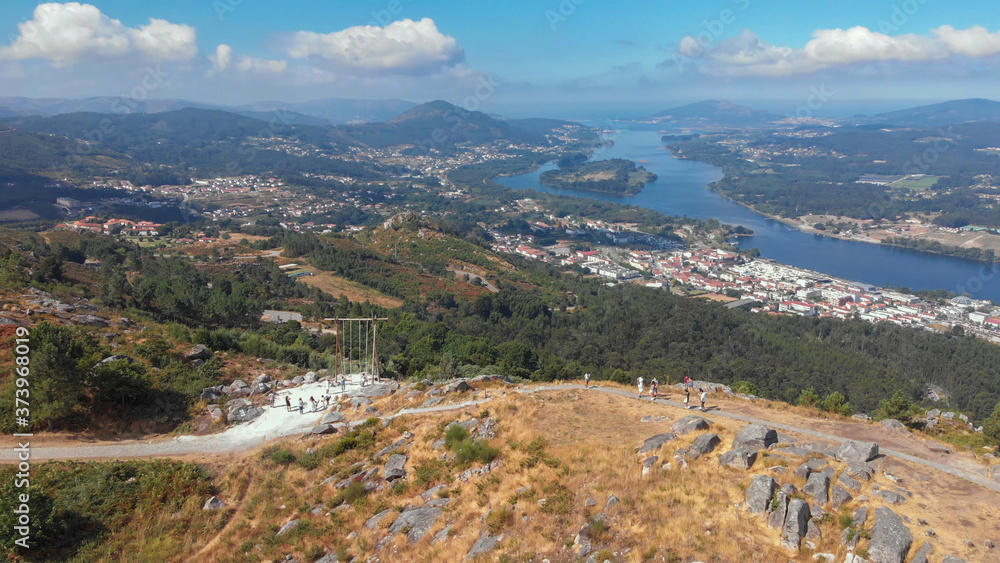 Aerial view of the CerLove giant wooden swing in Vila Nova de Cerveira, Portugal. The swing of the valley of Minho is next to the viewpoint of  of Cervo. People on swings admire the view.