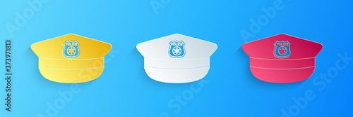 Paper cut Police cap with cockade icon isolated on blue background. Police hat sign. Paper art style. Vector.