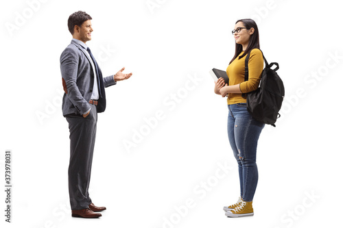 Full length profile shot of a female student and a man standing and talking photo