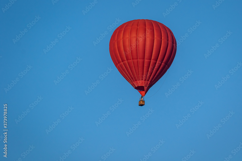 Bright red hot air balloon in flight against a background of blue sky. Colorful watercolor painting balloon flying high. Close-up. Bright red hot air balloon in flight against a background of blue sky. Colorful watercolor painting balloon flying high. Close-up.