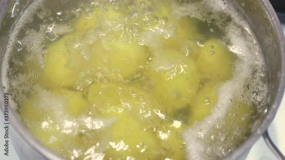close-up view of boiling water with yellow raw potatoes in a saucepan close-up view of boiling water with yellow raw potatoes in a saucepan
