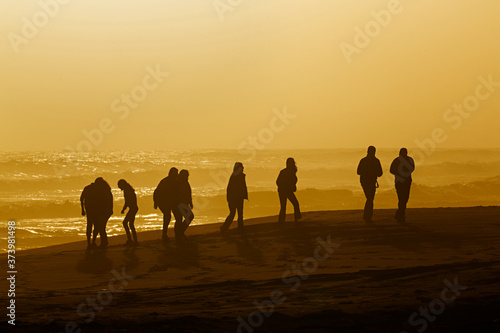 Grupo de personas andando por la playa al atardecer. © Lola Fdez. Nogales