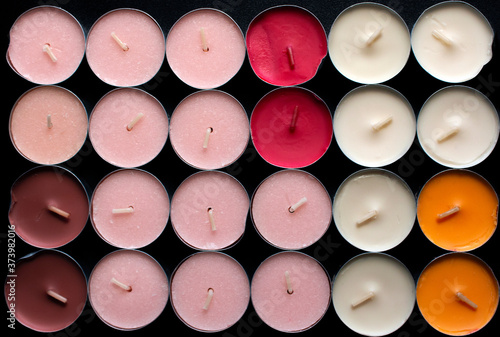 Top view of a group of colored Tea lights on black background 