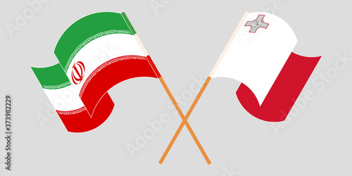 Crossed and waving flags of Iran and Malta