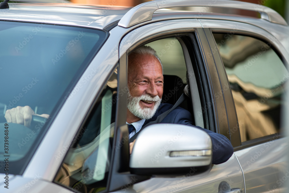 Happy senior man driving car