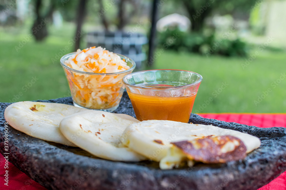 typical Salvadoran dish, cheese pupusas with cabbage and tomato sauce