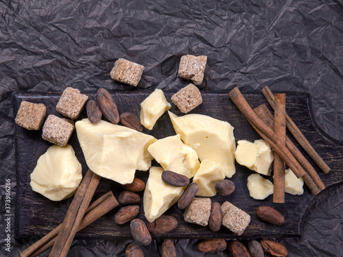 Pieces of natural cocoa butter with cinnamon, cocoa beans and cane sugar