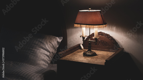 Canvas Print Bedside nightstand table with antique retro vintage lamp low key photography rel