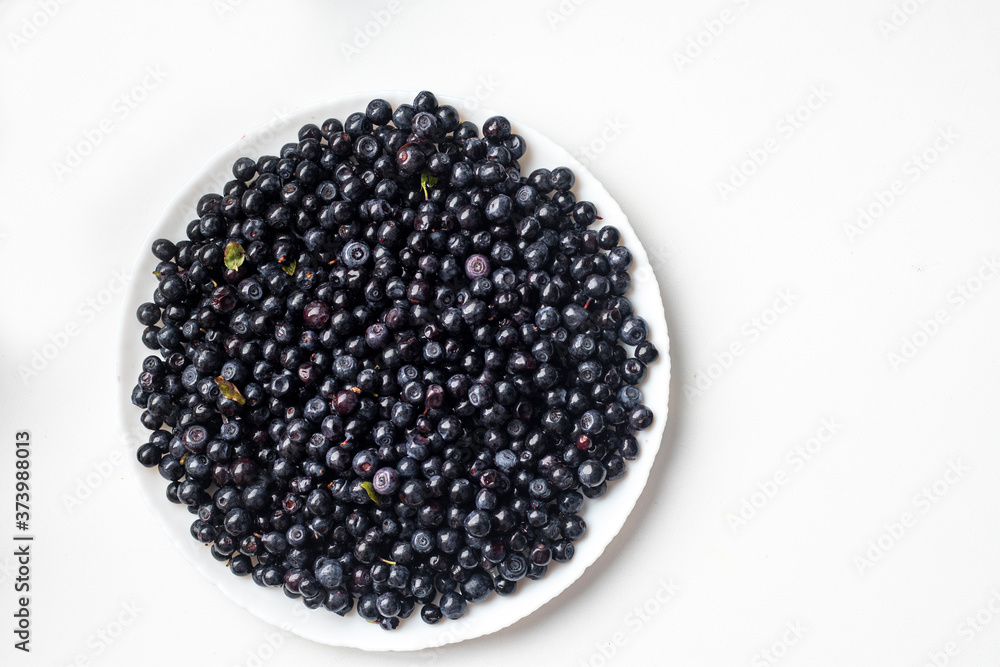 blueberries in a white plate on a white background top view blueberries in a white plate on a white background top view