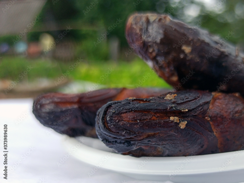 Smoked bream on a white plastic plate. Golden smoked fish close up top view. Hot smoked fish. Food photo.