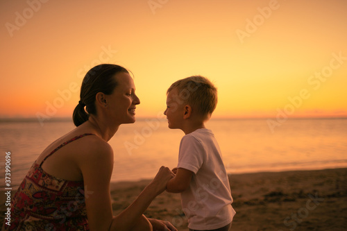 Happy mother and son interacting smiling on the beach 