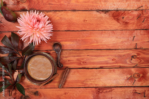 Autumn flower arrangement, abstract background flat lay, minimal concept of holiday, thanksgiving day, postcard. Cup of coffee with cinnamon and flowers on an old wooden table, photo