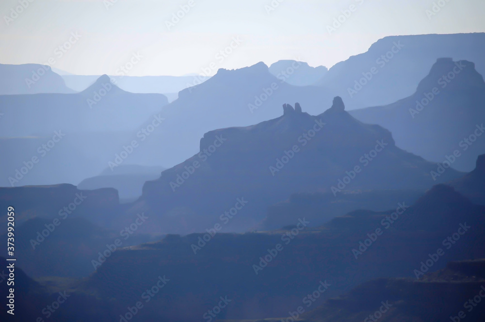 misty blue morning scene of distant mountains before sunrise at the grand canyon misty blue morning scene of distant mountains before sunrise at the grand canyon