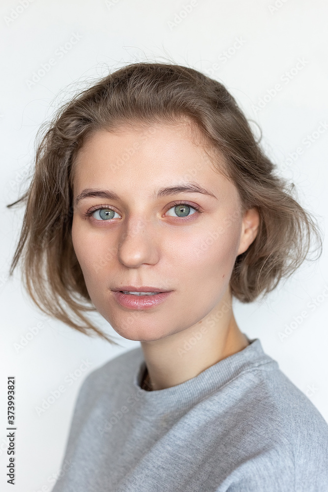 Portrait Of Caucasian Woman With Clean Skin And Short Hair Posing In Gray T Shirt On Black