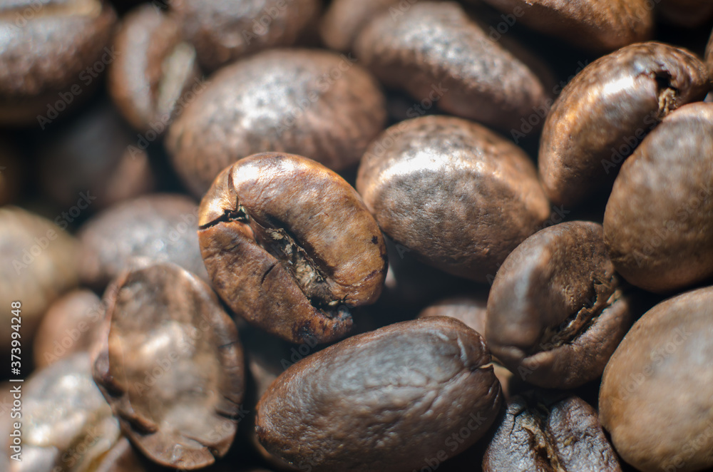 Close-up photo of roasted coffee beans with natural lighting. Background from coffee beans. Close-up photo of roasted coffee beans with natural lighting. Background from coffee beans.