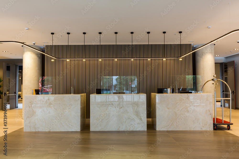Interior of a hotel lobby with reception desks with transparent covid