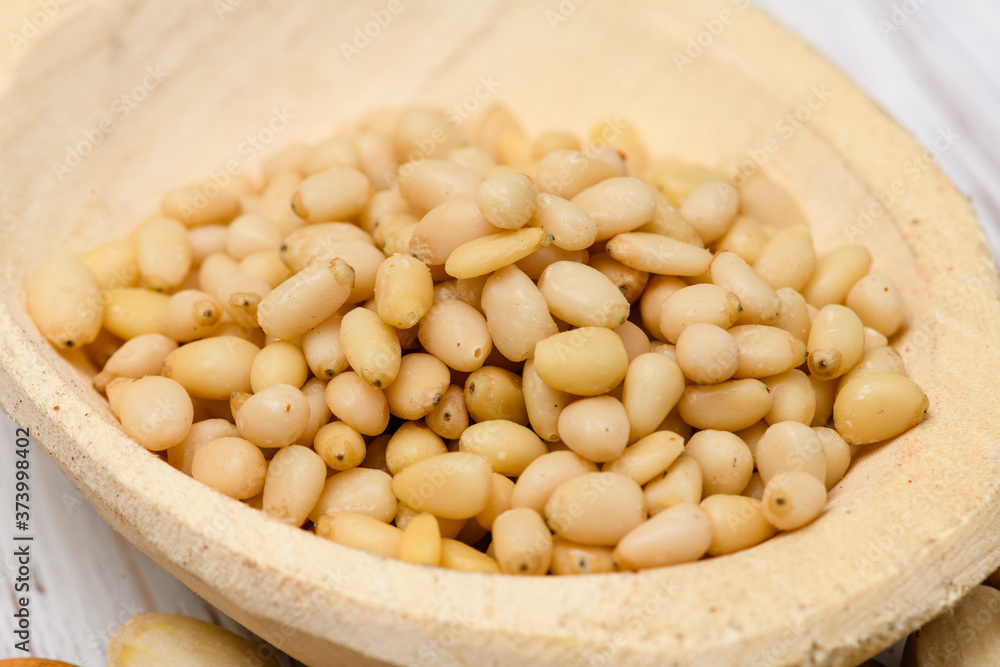 Pine nuts in a wooden spoon on a wooden background. Pine nuts in a wooden spoon on a wooden background.