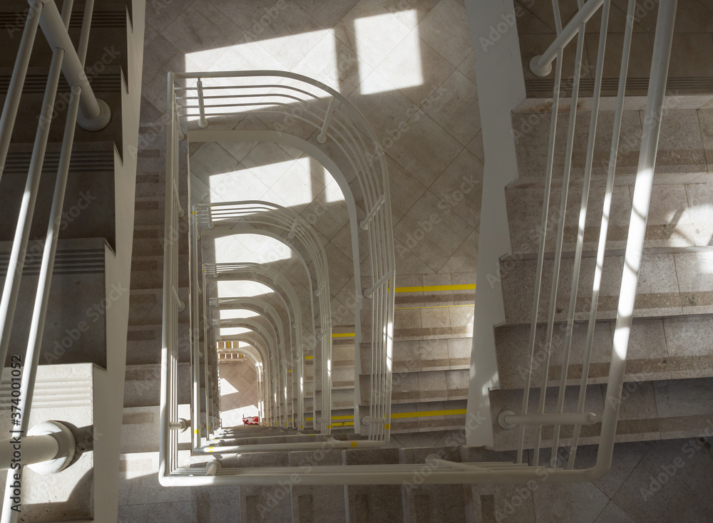 Obraz premium Top view of a staircase with a stream of light falling from the windows onto the landing