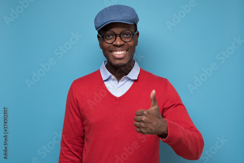 african man with cheerful facial emotion showing thumb up