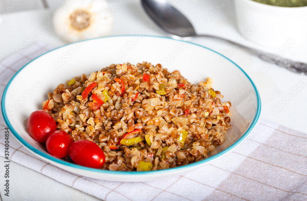Buckwheat pilaf (pilav) with vegetable in dish on wooden background. Buckwheat pilaf (pilav) with vegetable in dish on wooden background.