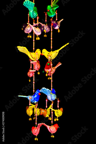 Colorful bird hangings on black background
