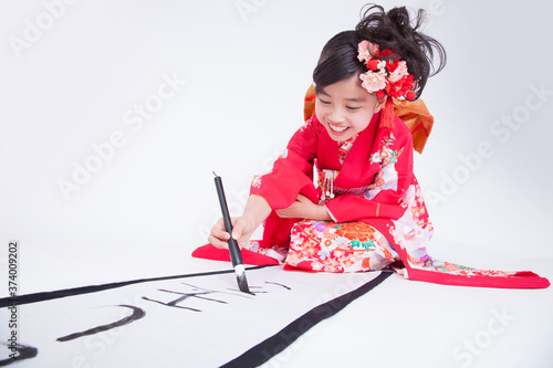 振り袖姿で書き初めをする女児 photo