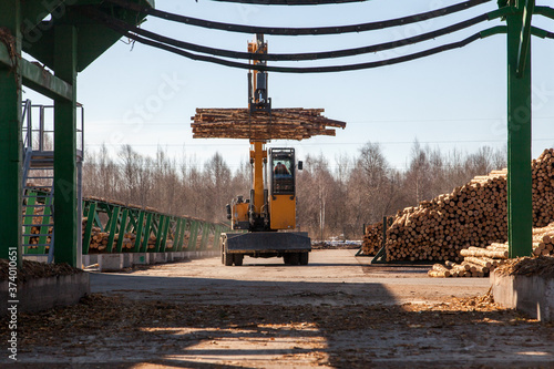 Industrial loader transports logs at a sawmill
