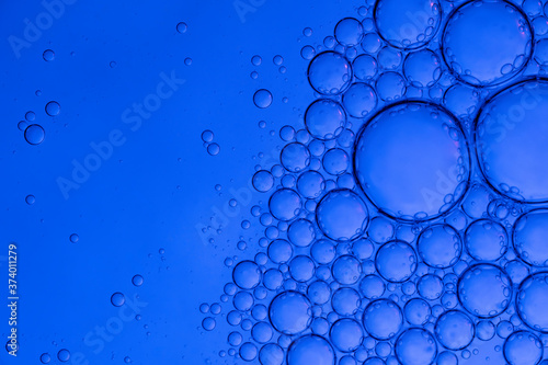 Different size bubbles undewater on blue background. Macro photo. 