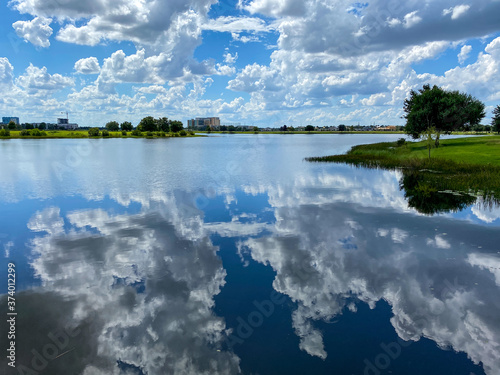 The clouds in the sky reflecting on a calm peaceful lake © Joni