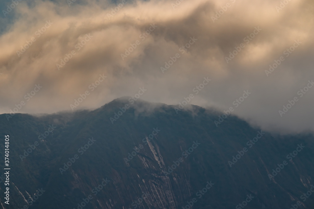 clouds over the slopes with erosion marks on the mountain slopes of the Serra do Mar.