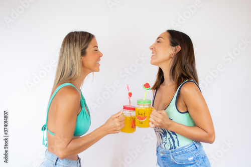 Two pretty women in swimwear with a cocktail
