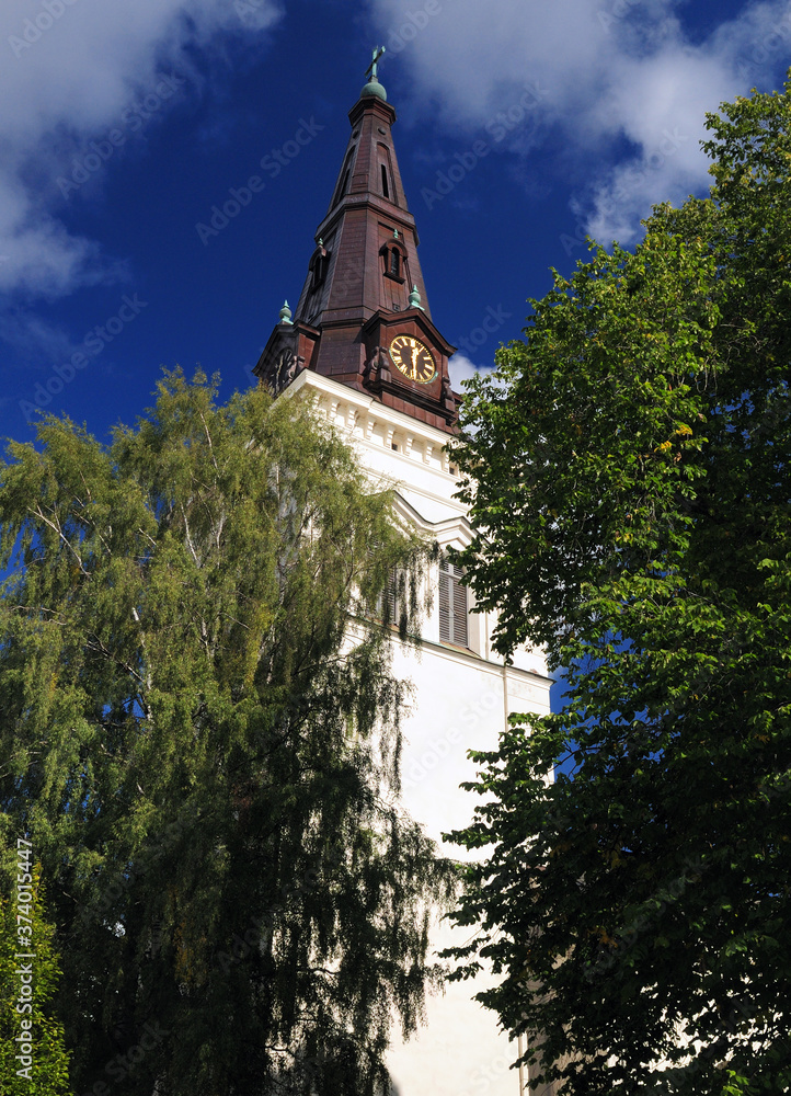 Clock Tower Of Domkyrka Cathedral In Karlstad On A Sunny Summer Day With A Clear Blue Sky Clock Tower Of Domkyrka Cathedral In Karlstad On A Sunny Summer Day With A Clear Blue Sky