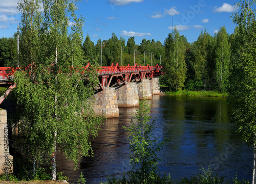 Red Wooden Bridge Lejonstromsbron In Skelleftea On A Sunny Summer Day With A Clear Blue Sky