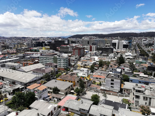 View of a modern city with buildings and cars, mountains and the sky in the background during a summer day