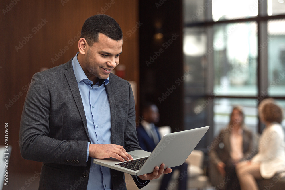 Executivo latino trabalhando em computador portátil.