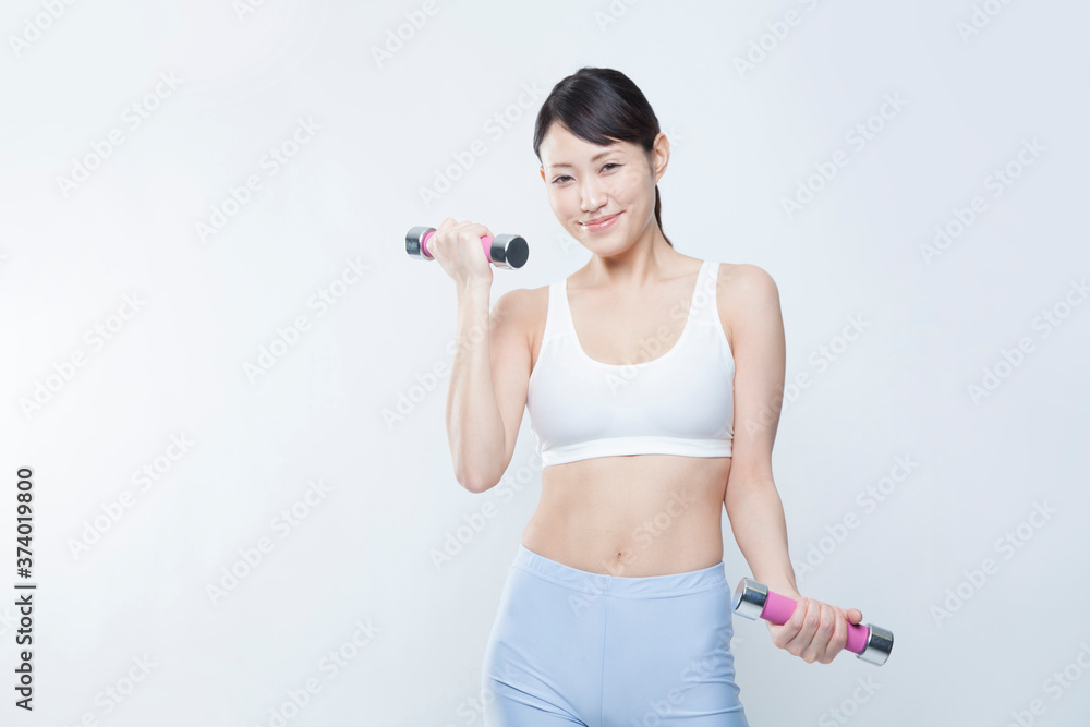 ダンベルで筋トレする女性 ダンベルで筋トレする女性