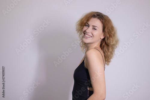 emotional portrait of a beautiful curly blonde-redhead in black undershirt. High quality photo