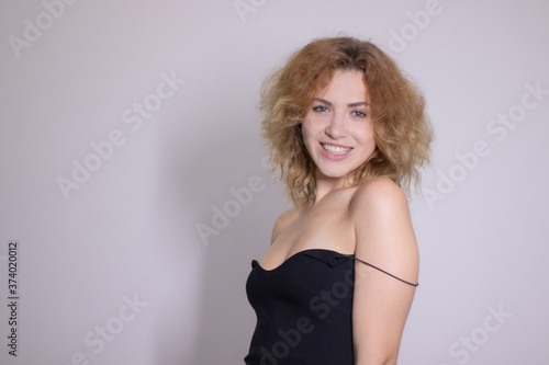 emotional portrait of a beautiful curly blonde-redhead in black undershirt. High quality photo