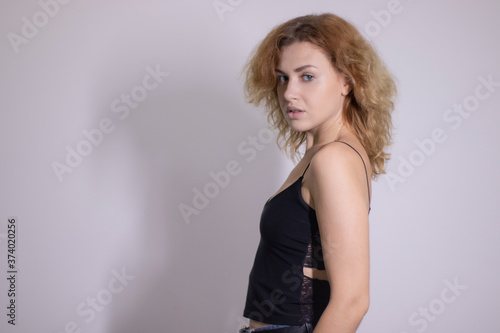 emotional portrait of a beautiful curly blonde-redhead in black undershirt. High quality photo