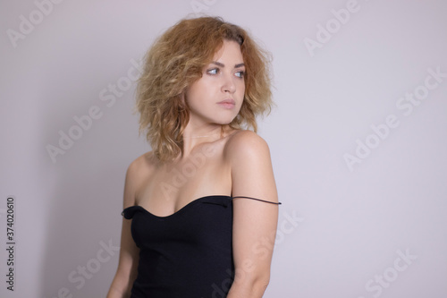 emotional portrait of a beautiful curly blonde-redhead in black undershirt. High quality photo © OliaVesna