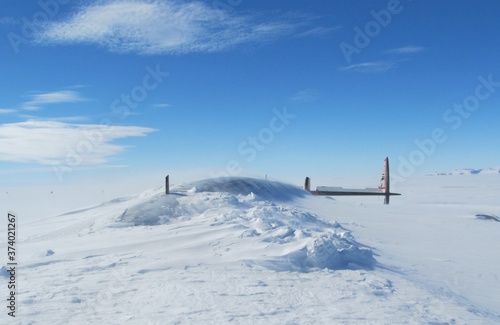 Pegasus Plane Crash Site with fuselage and tail above snowline, buried in Antarctica