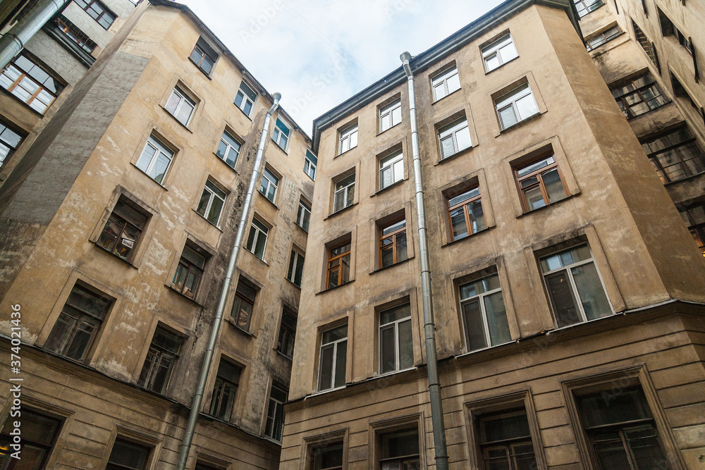 The courtyard of an old apartment building in St. Petersburg with yellow shabby walls